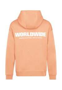 Helle Pfirsich-Hoodie mit einer Kängurutasche und einer verstellbaren Kapuze. Auf der Rückseite prangt fetter, weißer Text: "WELTWEITE SUBLEVEL-KOLLEKTION - SEI DIR SELBST TREU."