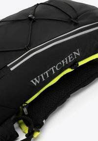 Zaino nero con dettagli in rete e accenti verde neon. Presenta un sistema di corda bungee e strisce riflettenti. Il nome del marchio "WITTCHEN" è in evidenza.