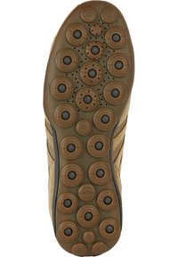 Hnědá gumová podrážka obuvi s kulatými, vyvýšenými kruhovými vzory a ventilačními otvory. Texturované detaily podél okrajů a viditelné logo.