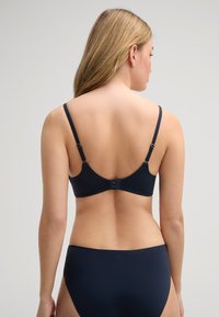 Marineblå bh med justerbare stropper og krog-lukning; glat stof med en sømløs design, parret med matchende marineblå bikini-trusser.