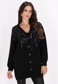 Schwarze Strickjacke mit V-Ausschnitt, verziert mit bunten Pailletten im Tropfenmuster, mit Knopfverschluss und gerippten Bündchen.