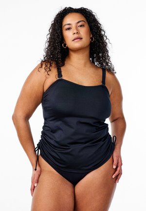 Der schwarze Badeanzug verfügt über verstellbare Träger, geraffte Seiten und eine elegante, glatte Textur. Das Design umfasst einen passenden Bikini-Unterteil.