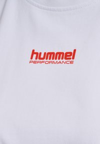 Hvid bomuld T-shirt med et rødt "hummel PERFORMANCE" logo. Stoffet er glat med en let tekstur og har en rund hals.
