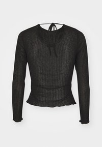 Schwarzes Langarmoberteil aus strukturiertem Stoff mit Rippendesign. Mit Rundhalsausschnitt und einer Bindeschleife im Rücken.