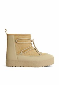 Beige ankelstøvle lavet af ruskind og glat materiale, med en rund tå, struktureret sål og snørebåndsdesign med løbegangjustering.