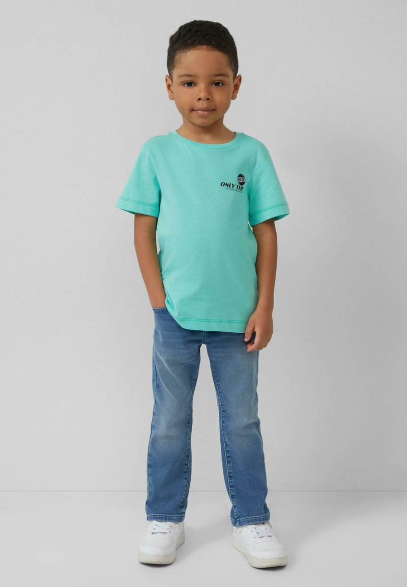 Turkooise t-shirt met korte mouwen en zwart print, gecombineerd met lichtblauwe denim jeans en witte sneakers. Glad materiaal, casual pasvorm.