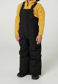 Sorte isolerede snobukser med justerbare stropper, frontknaplukning og lynlåslommer i siden, båret over en gul fleece-trøje.