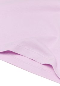 Helles rosa Gewebe mit einer weichen Textur, das eine gefaltete Kante und sichtbare Nähte aufweist und eine glatte Oberfläche ohne Muster zeigt.