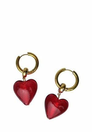 Boucles d'oreilles en or en forme de créoles, chacune avec un pendentif translucide rouge en forme de cœur suspendu sur fond blanc.