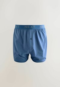 Modré bavlnené boxerky s hladkým predným dielom, zapínaním na jeden gombík a mäkkým elastickým pásom s názvom značky v kontrastnej farbe.