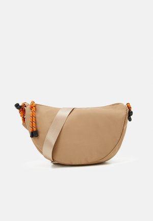 Sac bandoulière beige en forme de croissant avec une large sangle et des accents de cordon orange-noir sur un fond blanc.