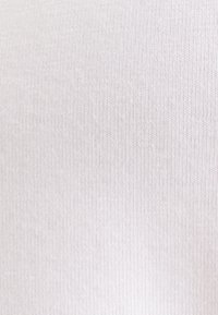 Primo piano di tessuto grigio chiaro a coste con motivo a maglia verticale e cuciture fini e regolari.