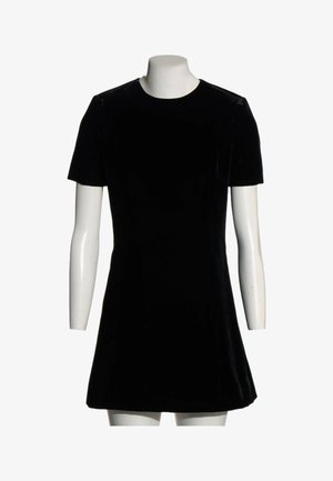 Robe noire en velours à manches courtes avec un col rond, exposée sur un mannequin blanc sans tête sur fond blanc.