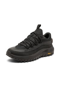Musta vaelluskengät, joissa on teksturoitu päällinen, kestävä kumipohja ja mustat nauhat. Varustettu vahvistetulla kärjellä ja Vibram-logolla pohjassa.