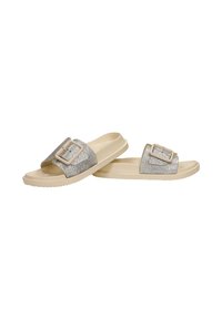 Sandales beige à enfiler avec larges brides argentées pailletées et grandes boucles carrées, semelles plates, bords inférieurs légèrement texturés.