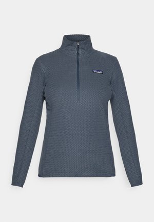 Pullover in pile tessuto grigio scuro con maniche lunghe, colletto alto, zip a un quarto e logo Patagonia sul lato sinistro del petto.