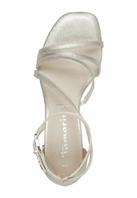 Metallisk silver högklackad sandal med flera tunna remmar, en fyrkantig tådesign och en spänne vid vristen för fastsättning. Slät textur.