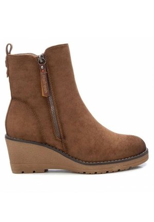 Botte cheville en daim marron avec fermeture éclair latérale, talon compensé et languette à l'arrière, conçue pour un usage décontracté.