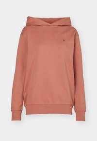 Sudadera color óxido con mangas largas, capucha doblada, puños y dobladillo acanalados, y un pequeño logo negro "ck" en el pecho.