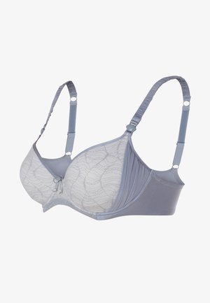 Soutien-gorge gris clair avec superposition de dentelle, bonnets moulés et bretelles réglables. Il présente une finition lisse et un détail décoratif au centre.