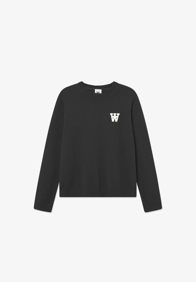 Suéter negro de punto con mangas largas, cuello y dobladillo acanalados. Presenta un logo blanco de 'W' en la parte izquierda del pecho. Textura suave.