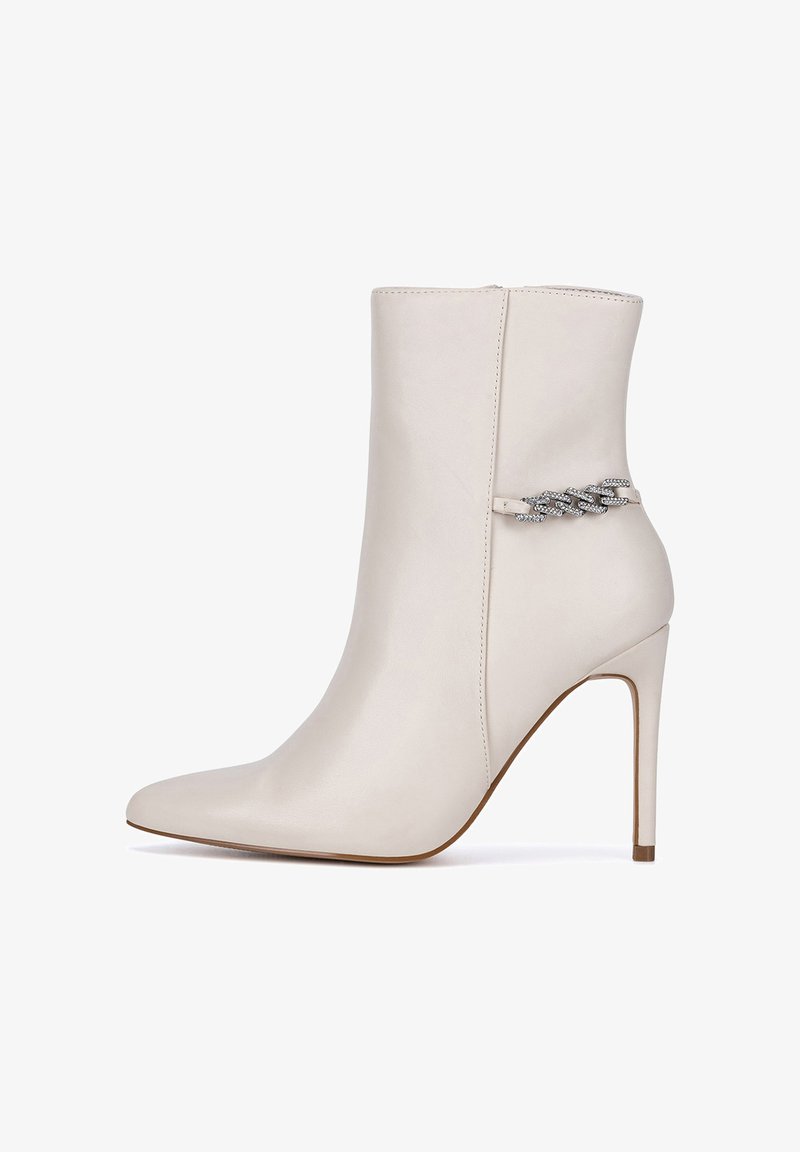 Smėlio spalvos odiniai kulkšnies batai su smailiu priekiu, smailia kulno forma ir dekoratyvine grandinės detale šone. Lygi tekstūra ir elegantiškas dizainas.