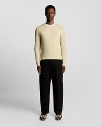 Ανοιχτό κίτρινο μακρυμάνικο πουλόβερ με ριμπ υφή και στρογγυλή λαιμόκοψη, σε συνδυασμό με μαύρο παντελόνι και sneakers με σχέδια.