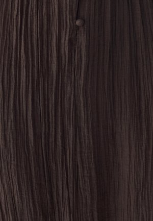 Teksturično rjava tkanina z navpičnimi naborki in majhnim usklajenim gumbom, ki prenaša mehak, gubast videz.