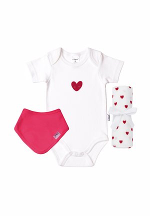 Weißer Baby-Body mit einem roten, lächelnden Herz, rotem Baby-Lätzchen und zusammengerollter weißer Decke mit roten Herzmustern, die mit einem weißen Band gebunden ist.