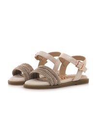 Sandali beige con tre cinghie larghe, una delle quali decorata con perline metalliche, e una cinghia alla caviglia con fibbia. Suola piatta con una soletta testurizzata.