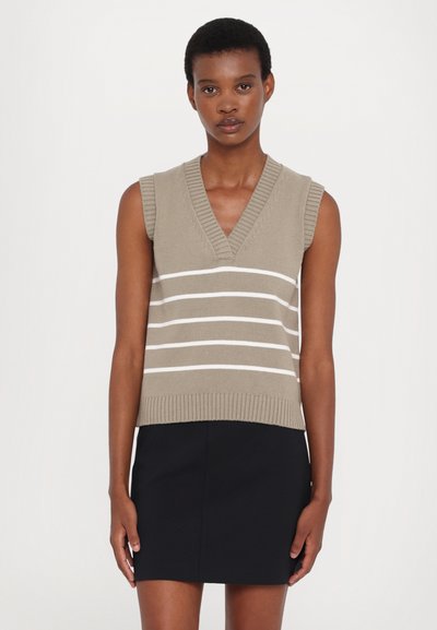 Beez värvi ilma varrukateta kudum, millel on valged horisontaalsed triibud, V-kujuline kaelus, soonikkoes äärisega, kombineeritud musta seelikuga. Sile tekstuur, igapäevane disain.