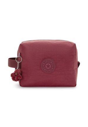 Red textured zippered toiletry bag with a round logo, adjustable handle, and pom-pom keychain attached. Rectangular design.