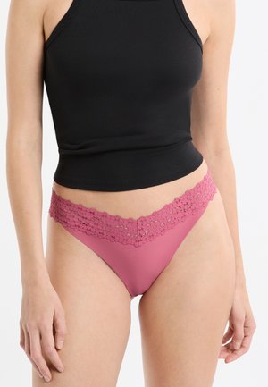 Pink thong underwear with a scalloped lace waistband, featuring a smooth, solid fabric body and a low-rise cut.