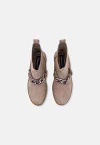 Botas de tobillo de ante gris con un acento de cadena plateada gruesa en la parte delantera y una lengüeta en bucle en la parte trasera para facilitar su uso.