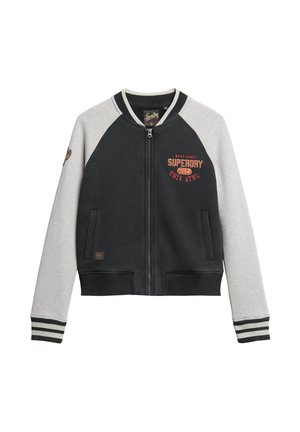 Sort og grå lynlåsbomberjakke med raglanærmer, ribstrikkede manchetter og linning. Har et logo og tekst på forsiden. Blød stofstruktur.