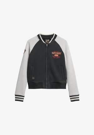 Sort og grå lynlåsbomberjakke med raglanærmer, ribstrikkede manchetter og linning. Har et logo og tekst på forsiden. Blød stofstruktur.