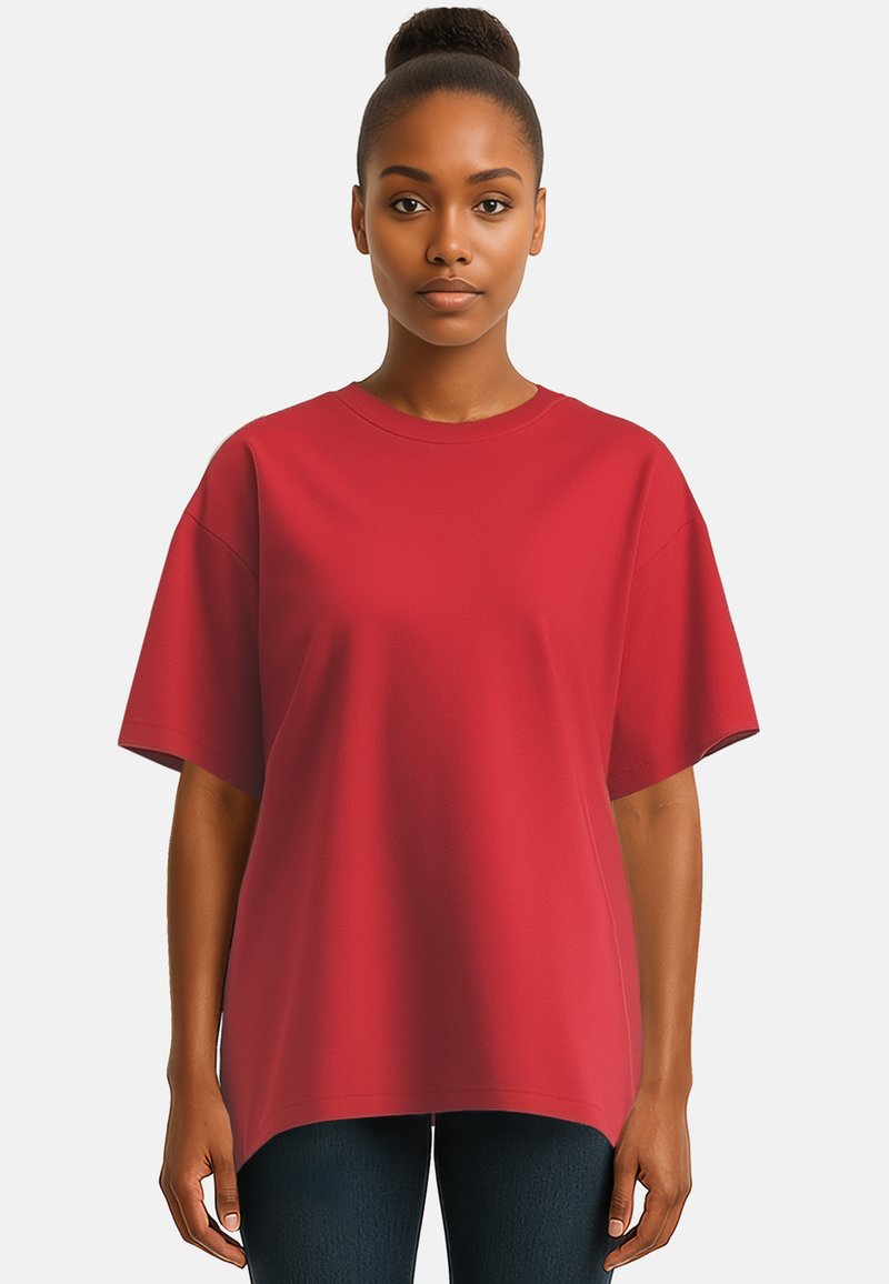 T-shirt rosso oversize con maniche corte, scollatura rotonda e una texture morbida simile al cotone. Abbinato a jeans scuri.