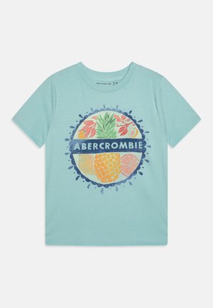 Jasnoniebieska dziecięca koszulka z okrągłą grafiką owoców przedstawiającą ananasa, plasterki cytrusów, liście oraz napis "ABERCROMBIE" na środku.