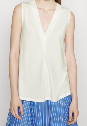 Ærmeløs top med v-hals lavet i blødt og let materiale. Kræmfarvet med en afslappet pasform, der har en lige kant. Enkel og minimalistisk design.