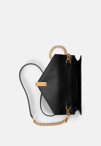 Borsa a tracolla in pelle nera con forma geometrica, caratterizzata da un dettaglio di catena dorata, una tracolla piatta e una chiusura dorata. Il design aperto rivela lo spazio interno.