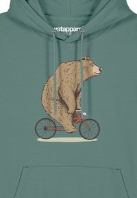 Teeuwkleurige hoodie met een grafisch ontwerp van een bruine beer die op een rode fiets rijdt, met gedetailleerde vachttextuur en een speelse uitdrukking.