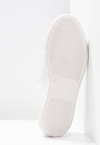 Bílá podrážka tenisky s vzorem rybí kosti, gumový materiál a zaoblený okraj, s velikostí 37 na straně.