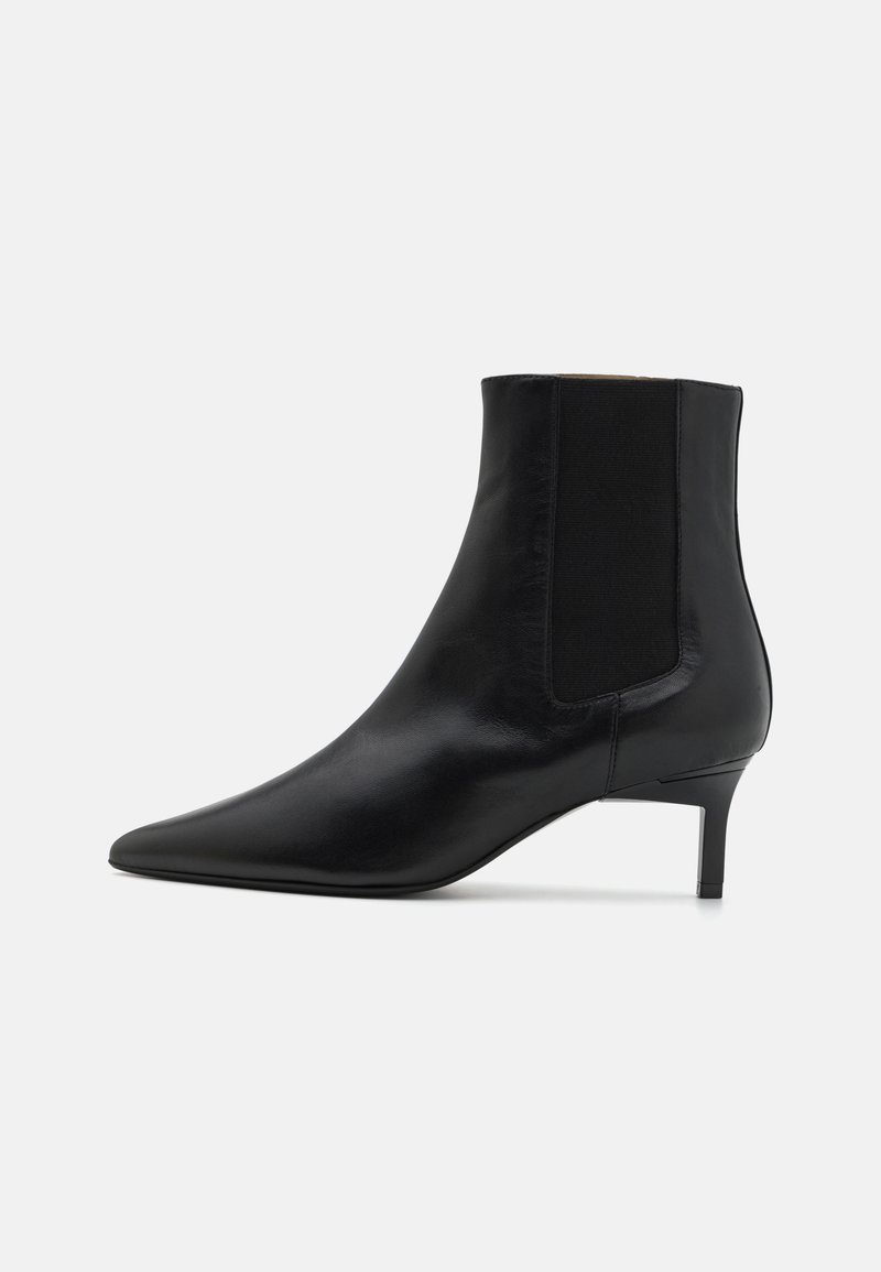 Botină din piele neagră până la gleznă, cu vârf ascuțit, panouri laterale elastice și toc subțire, având o textură netedă și un design minimalist.
