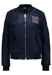 Veste bomber bleu marine avec col, poignets et ourlet côtelés, fermeture éclair frontale, poches latérales, poche zippée sur la manche et écusson brodé "H" sur la poitrine.
