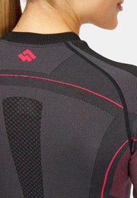 Czarna koszulka sportowa z teksturowanym wykończeniem, z czerwonymi akcentami i geometrycznym logo z tyłu. Projekt zawiera dopasowany kołnierz.