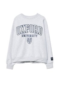 Svijetlosivi dukserica s natpisom "OXFORD UNIVERSITY" i grbom sveučilišta otisnutim u tamnoplavoj boji na prednjoj strani, s rebrastim manžetama i rubom.
