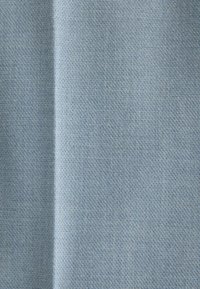 Tissu bleu clair doux avec une texture tricotée fine et uniforme et un pli vertical subtil créant une ombre le long de sa longueur.