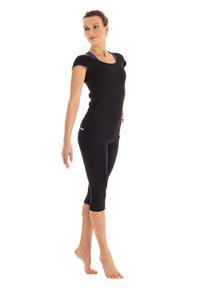 Schwarzes T-Shirt mit kurzen Ärmeln und schwarze Capri-Leggings. Glattes Material mit tailliertem Schnitt. Das T-Shirt hat einen runden Halsausschnitt und lila Akzente.