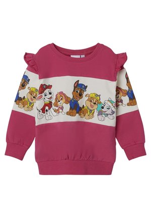 Børns lyserøde sweatshirt med lange ærmer og flæser på skuldrene med en Paw Patrol-karakterbånd i blå, gul, rød og hvid uniform.