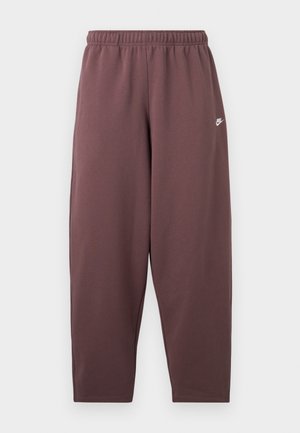 Pantalones deportivos de corte holgado en color malva oscuro con cintura elástica y pequeño logo Nike swoosh blanco en la parte superior del muslo.